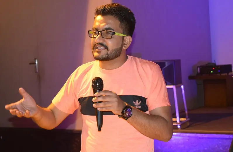 Imtiaz Hussain speaking on stage with a microphone